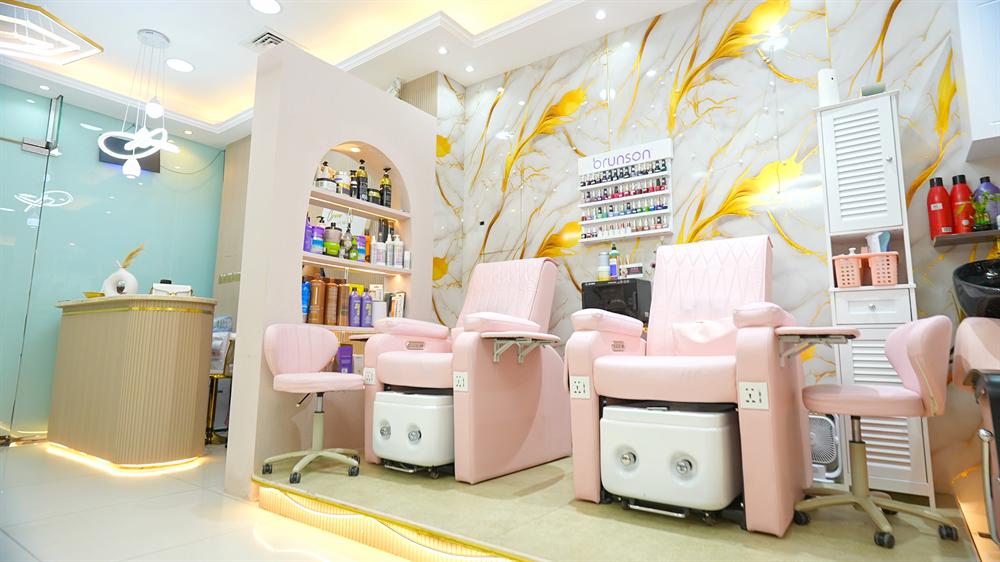 Bright salon interior with pink treatment chairs and gold marble walls