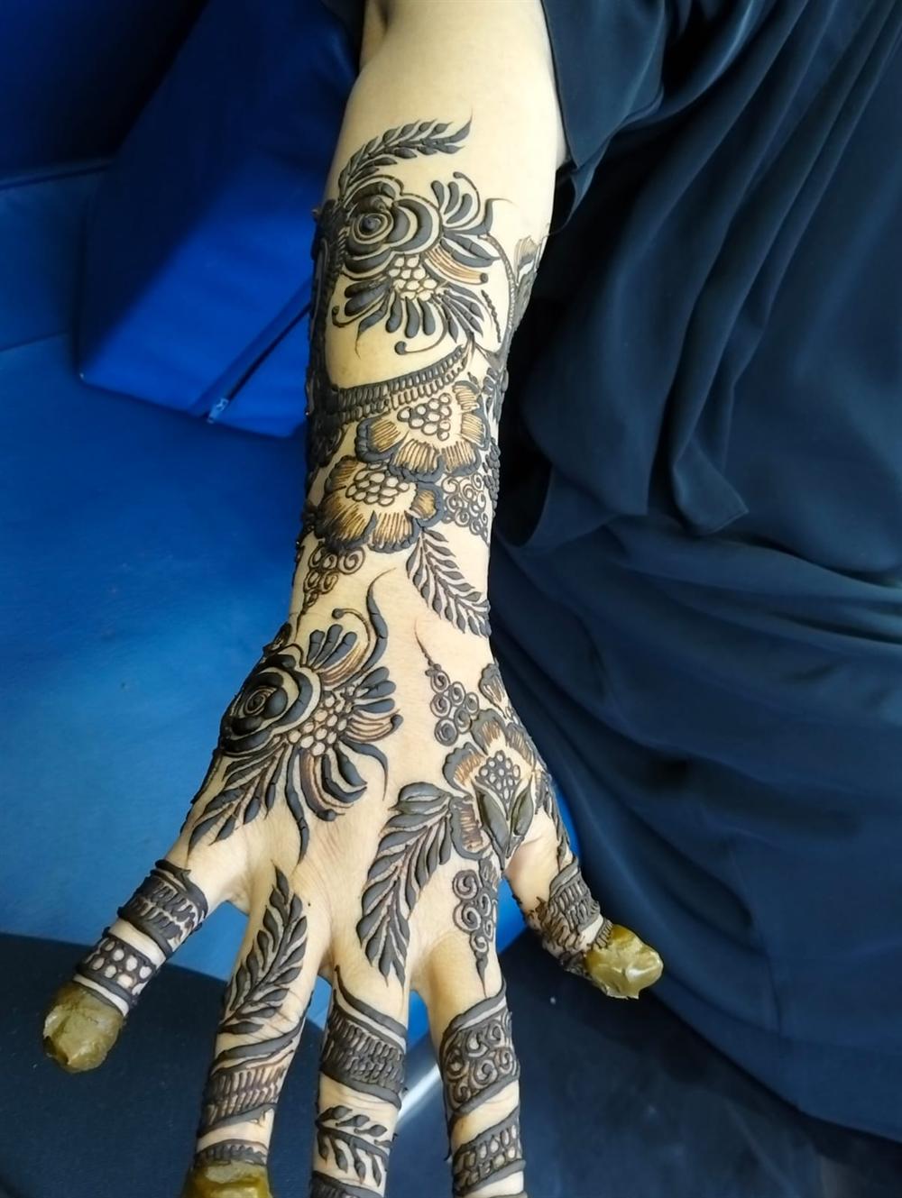 Intricate bridal henna covering the hand and forearm