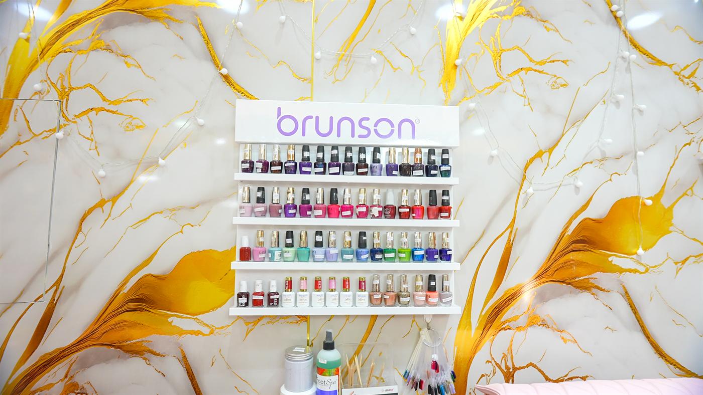Wall display of colorful nail polishes on gold marble