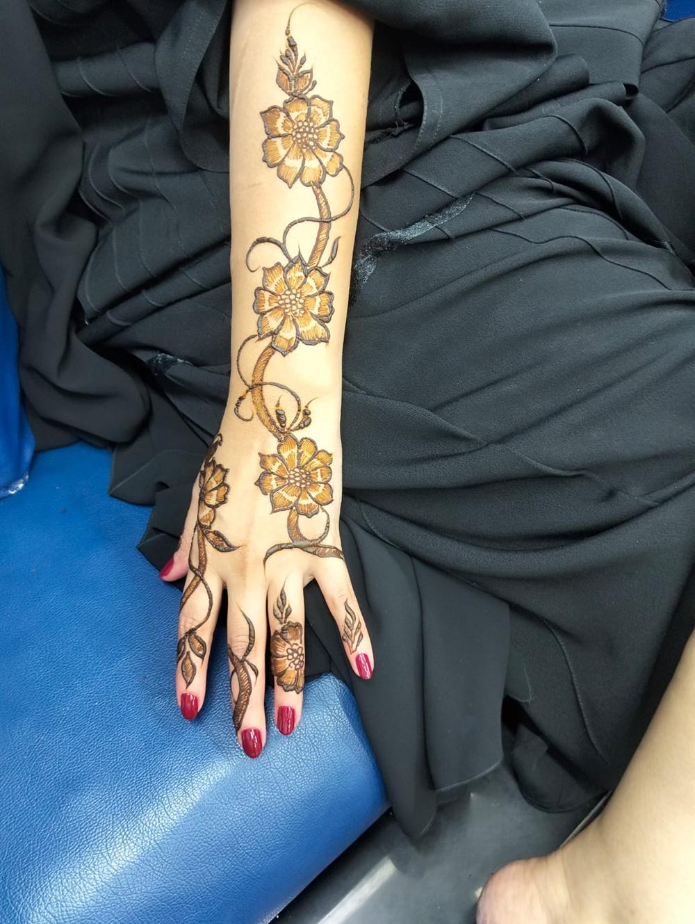 Floral henna design flowing along the hand and forearm