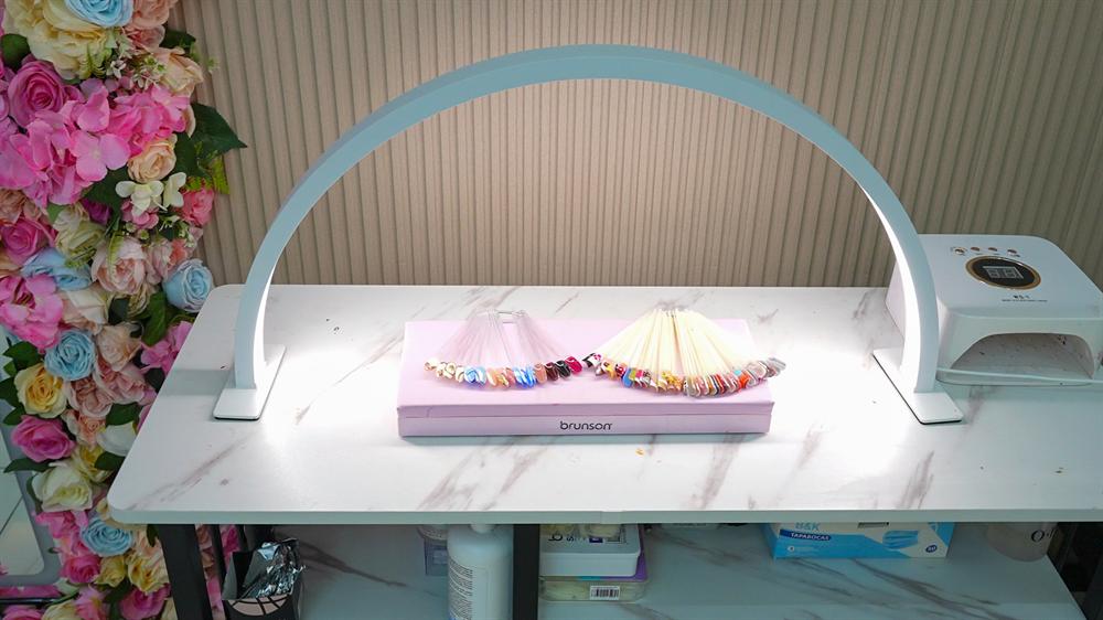 Nail studio desk with nail art swatches and UV lamp