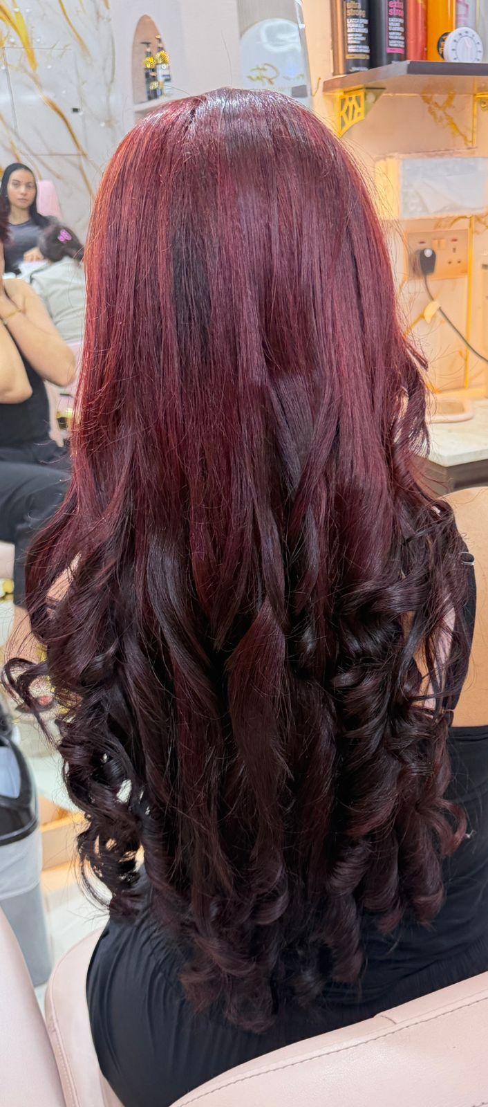 Rich burgundy hair color transformation with glossy curls