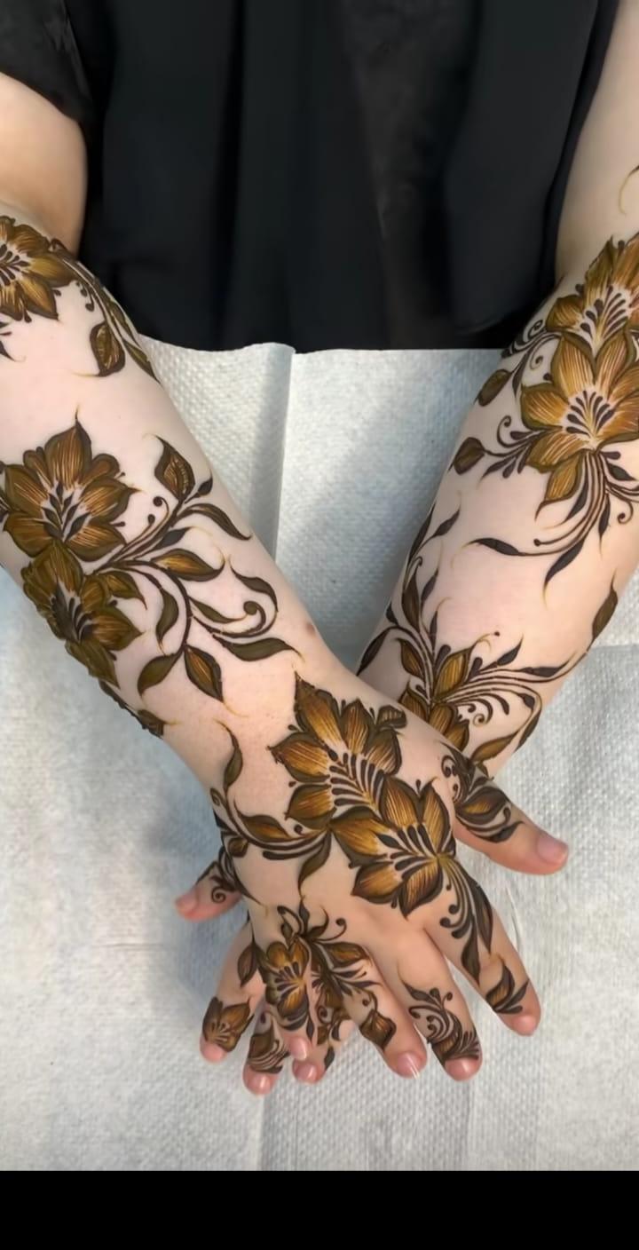 Detailed bridal henna covering both forearms
